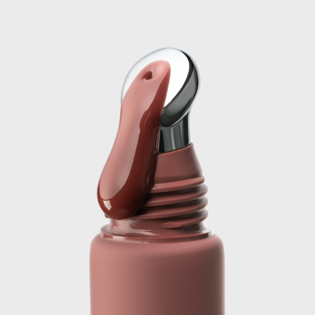 Close-up of spice cake gloss with a silver applicator on a light gray background
