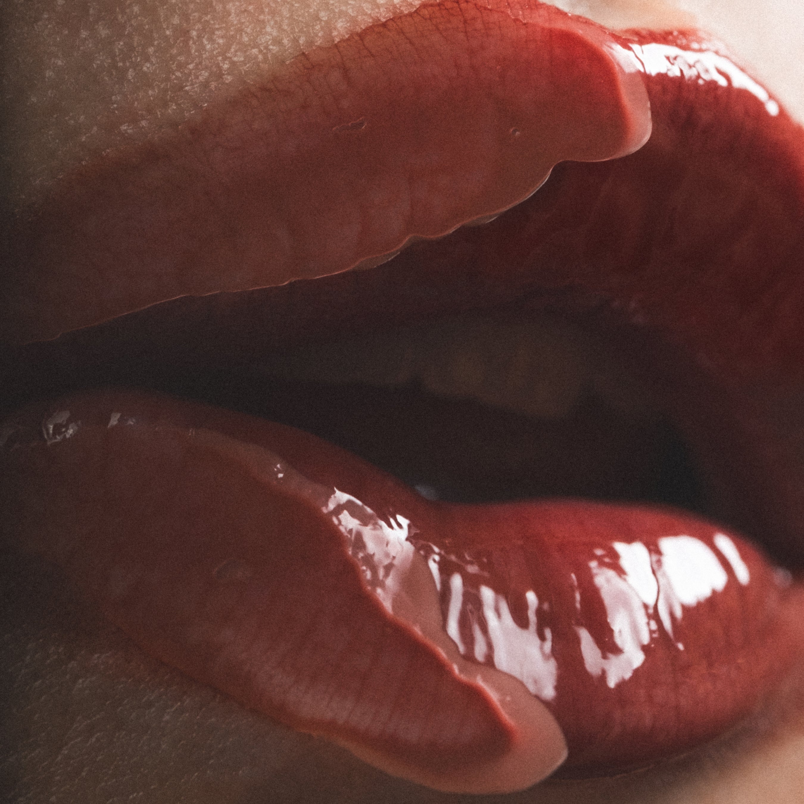 Close-up of glossy red lips with a blurred background